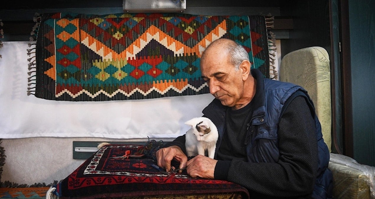 Balıkesir’de halı tamircisi depremler nedeniyle kedisiyle karavanda çalışıyor
